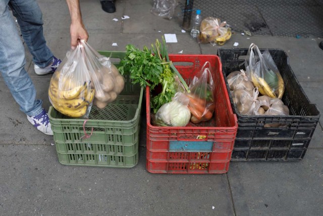 A vendor puts bags with bananas and potatoes on a plastic case at a street market in Caracas, Venezuela November 3, 2017. Picture taken November 3, 2017. REUTERS/Marco Bello