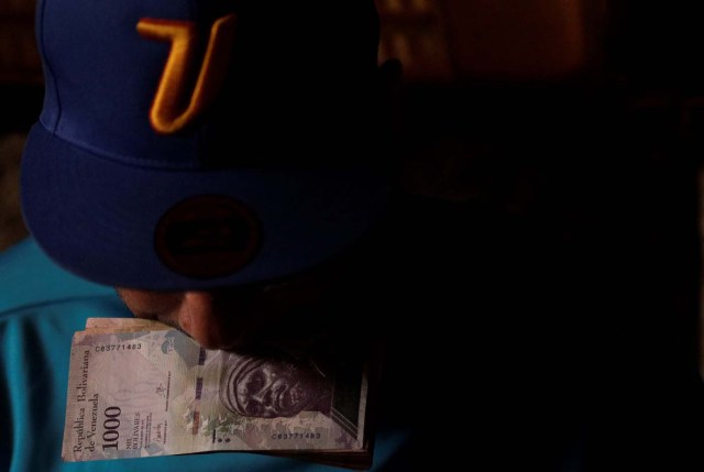 A man counts his money to place bets on horse racing at a small warehouse on the outskirts of Caracas, Venezuela, October 7, 2017. REUTERS/Ricardo Moraes SEARCH "MORAES GAMBLING" FOR THIS STORY. SEARCH "WIDER IMAGE" FOR ALL STORIES.