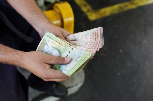 Un trabajador cuenta bolívares venezolanos en una gasolinera de la petrolera estatal venezolana PDVSA en Caracas, Venezuela el 21 de marzo de 2017. REUTERS / Marco Bello