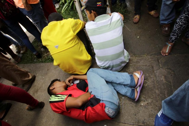 A young man lies on the floor outside a health center as he waits to gets treatment for malaria, in San Felix, Venezuela November 3, 2017. Picture taken November 3, 2017. REUTERS/William Urdaneta