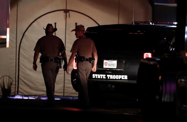 Dos Texas State Troopers pasan frente a una tienda de campaña cerca de donde tuvo lugar un tiroteo masivo en la Primera Iglesia Bautista en Sutherland Springs, Texas, EE.UU., el 05 de noviembre de 2017. Según informes de prensa, un pistolero identificado como Devin Patrick Kelley, de 26 años, se acercó al iglesia y abrió fuego afuera, luego entró a la iglesia y continuó disparando, matando al menos a 26 personas. Kelley fue encontrado muerto en su vehículo después de una breve persecución, sin embargo, la causa de su muerte no está clara. (Abierto, Incendio, Estados Unidos) EFE / EPA / LARRY W. SMITH