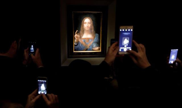 Varias personas fotografían la obra 'Salvator Mundi' del artista Leonardo da Vinci (1500), durante una vista previa pública antes de que la casa Christie's lo subaste por un precio estimado de 100 millones de dólares, en Nueva York (Estados Unidos) hoy, 15 de noviembre de 2017. 'Salvator Mundi' es la única obra del polímata florentino que queda en manos privadas. EFE/ Justin Lane