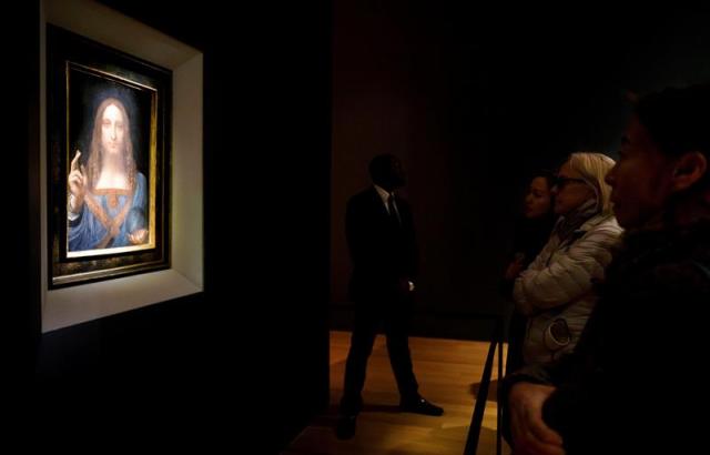 Varias personas observan la obra 'Salvator Mundi' del artista Leonardo da Vinci (1500), durante una vista previa pública antes de que la casa Christie's lo subaste por un precio estimado de 100 millones de dólares, en Nueva York (Estados Unidos) hoy, 15 de noviembre de 2017. 'Salvator Mundi' es la única obra del polímata florentino que queda en manos privadas. EFE/ Justin Lane