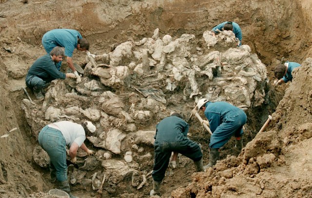 (ARCHIVOS) Esta foto de archivo tomada el 24 de julio de 1996 muestra expertos forenses del tribunal internacional de crímenes de guerra en La Haya trabajando en una pila de cuerpos parcialmente descompuestos hallados en una fosa común en la aldea de Pilica, a unos 300 km al noreste de Sarajevo. El 22 de noviembre de 2017, los jueces del TPIY emitirán su veredicto sobre el jefe militar serbio bosnio Ratko Mladic, quien enfrenta 11 cargos que incluyen genocidio, crímenes de guerra y crímenes de lesa humanidad, que surgieron de la guerra de Bosnia de 1992 a 1995. / AFP PHOTO / ODD ANDERSEN