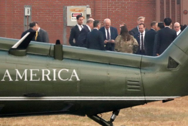 White House Chief of Staff John Kelly (looking at notes) huddles with White House senior staff to discuss the situation as U.S. President Donald Trump sits in his car after being grounded from an attempt to visit the Demilitarized Zone (DMZ) in the truce village of Panmunjom dividing North Korea and South Korea, at a U.S. military post in Seoul, South Korea, November 8, 2017. REUTERS/Jonathan Ernst