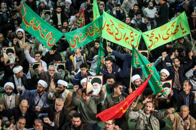 Iranians chant slogans as they march in support of the government near the Imam Khomeini grand mosque in the capital Tehran on December 30, 2017. Tens of thousands of regime supporters marched in cities across Iran in a show of strength for the regime after two days of angry protests directed against the country's religious rulers. / AFP PHOTO / TASNIM NEWS / HAMED MALEKPOUR