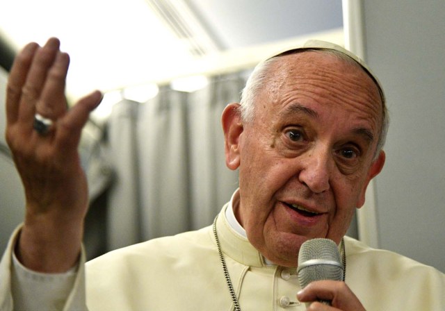 Pope Francis gestures during a news conference on board of the plane during his flight back from a trip to Myanmar and Bangladesh, December 2, 2017. REUTERS/Vincenzo Pinto/Pool