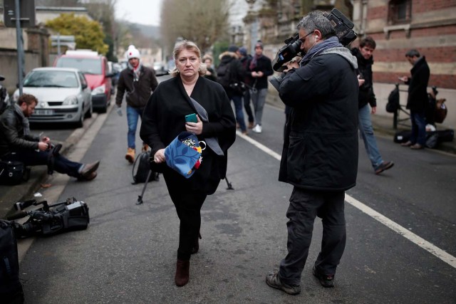 A woman arrives with a bouquet of flowers outside house of late French singer and actor Johnny Hallyday's in Marnes-la-Coquette near Paris, France December 6, 2017. REUTERS/Benoit Tessier