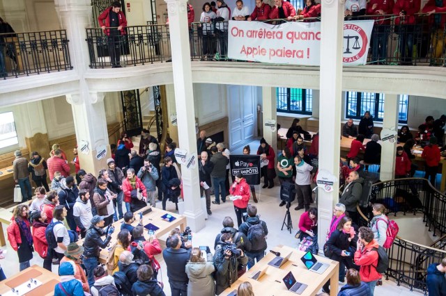 Paris (France), 02/12/2017.- Activists of ATTAC, an anti-globalization organization hold a banner reading 'We will stop when Apple will pay', in an Apple store to denounce the tax evasion used, according to them, by the American electronics group in Paris, France, 02 December 2017. (Protestas, Francia) EFE/EPA/CHRISTOPHE PETIT TESSON