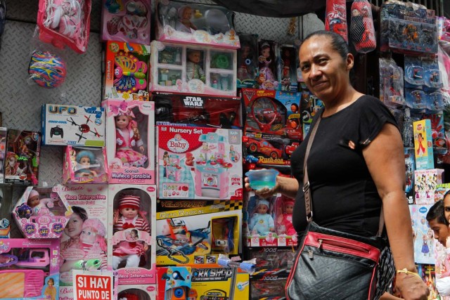 ACOMPAÑA CRÓNICA: VENEZUELA CRISIS - VZL02. CARACAS (VENEZUELA), 15/12/2017.- Fotografía del 14 de diciembre de 2017, de una mujer frente a una tienda de juguetes en Caracas (Venezuela). Los venezolanos podrán disfrutar este año brevemente de sus tradicionales estrenos de ropa, delicias gastronómicas o los juguetes del Niño Jesús como resultado de una situación que tiene a la mayoría de los ciudadanos del país con la soga económica al cuello. Los venezolanos reconocen que este año tendrán que escoger entre una de estas tres tradiciones o reducir el gasto en una de ellas para centrarse en una exclusiva, mientras que los más desfavorecidos no tendrán tanta suerte, a pesar de los bonos y pagas extras que ha empezado a entregar el Gobierno de Nicolás Maduro. EFE/Cristian Hernandez