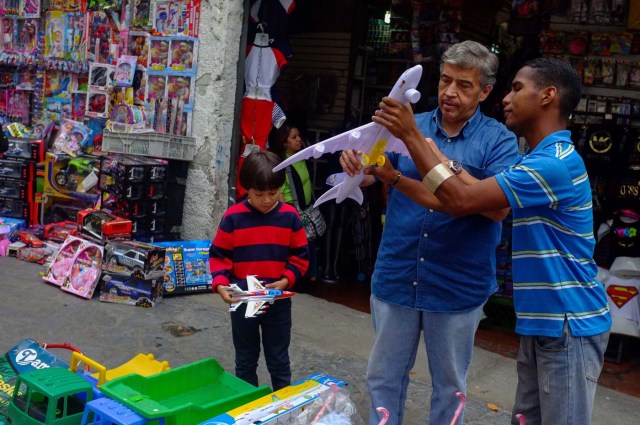 ACOMPAÑA CRÓNICA: VENEZUELA CRISIS - VZL06. CARACAS (VENEZUELA), 15/12/2017.- Fotografía del 14 de diciembre de 2017, de un hombre que vende juguetes en Caracas (Venezuela). Los venezolanos podrán disfrutar este año brevemente de sus tradicionales estrenos de ropa, delicias gastronómicas o los juguetes del Niño Jesús como resultado de una situación que tiene a la mayoría de los ciudadanos del país con la soga económica al cuello. Los venezolanos reconocen que este año tendrán que escoger entre una de estas tres tradiciones o reducir el gasto en una de ellas para centrarse en una exclusiva, mientras que los más desfavorecidos no tendrán tanta suerte, a pesar de los bonos y pagas extras que ha empezado a entregar el Gobierno de Nicolás Maduro. EFE/Cristian Hernandez