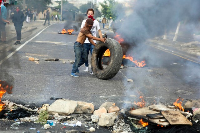 TGP02. TEGUCIGALPA (HONDURAS) 15/12/2017.- Manifestantes montan barricadas con escombros y llantas en llamas hoy, viernes 15 de diciembre de 2017, en Tegucigalpa (Honduras). Cientos de manifestantes bloquearon hoy importantes carreteras en las principales ciudades de Honduras en protesta por el presunto "fraude" en los comicios del 26 de noviembre contra el candidato de la Alianza de Oposición contra la Dictadura, Salvador Nasralla. EFE/Gustavo Amador