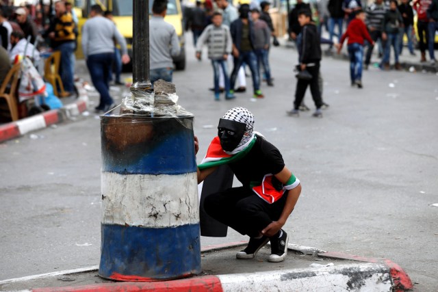 HEB18. HEBRÓN (PALESTINA), 20/12/2017.- Palestinos lanzan piedras a las tropas israelíes durante disturbios por la decisión del presidente estadounidense, Donald Trump, de reconocer Jerusalén como capital israelí, en Hebrón (Palestina) hoy, 20 de diciembre de 2017. EFE/ Abed Al Hashlamoun