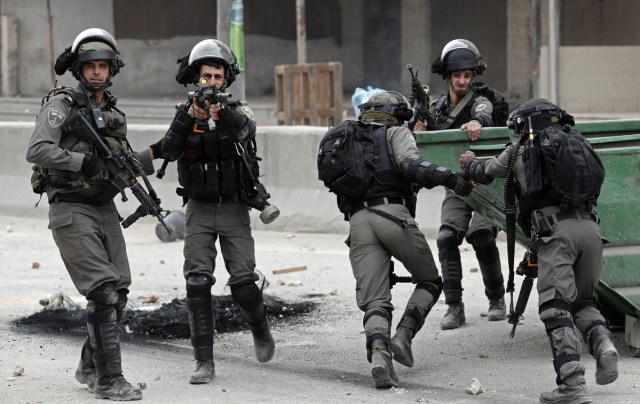 Israeli border police hold a position during clashes with Palestinian protestors near the Qalandia checkpoint in the Israeli occupied West Bank on December 20, 2017 as protests continue following the US president's controversial recognition of Jerusalem as Israel's capital. / AFP PHOTO / THOMAS COEX