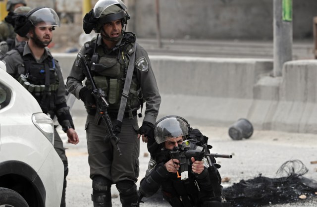 Israeli border police hold a position during clashes with Palestinian protestors near the Qalandia checkpoint in the Israeli occupied West Bank on December 20, 2017 as protests continue following the US president's controversial recognition of Jerusalem as Israel's capital. / AFP PHOTO / THOMAS COEX