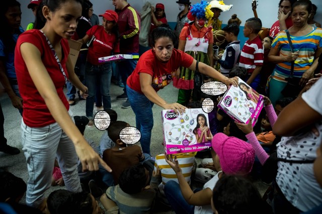 ACOMPAÑA CRÓNICA: VENEZUELA CRISIS. CAR11. CARACAS (VENEZUELA), 24/12/2017.- Niños reciben regalos de parte del Gobierno este viernes, 22 de diciembre de 2017, en una escuela pública al oeste de Caracas (Venezuela). El Niño Jesús no llevará regalos a muchos de los hogares de escasos recursos de Venezuela, pese a los millones de juguetes que el Gobierno de Nicolás Maduro ha asegurado que repartirá en todo el país, pues las familias dicen sentirse abandonadas y sumergidas en la crisis económica y social. EFE/Miguel Gutiérrez