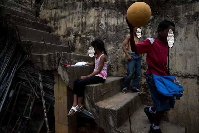 ACOMPAÑA CRÓNICA: VENEZUELA CRISIS. CAR04. CARACAS (VENEZUELA), 24/12/2017.- Niños juegan con una pelota este viernes, 22 de diciembre de 2017, en una barriada de Petare, en Caracas (Venezuela). El Niño Jesús no llevará regalos a muchos de los hogares de escasos recursos de Venezuela, pese a los millones de juguetes que el Gobierno de Nicolás Maduro ha asegurado que repartirá en todo el país, pues las familias dicen sentirse abandonadas y sumergidas en la crisis económica y social. EFE/Miguel Gutiérrez