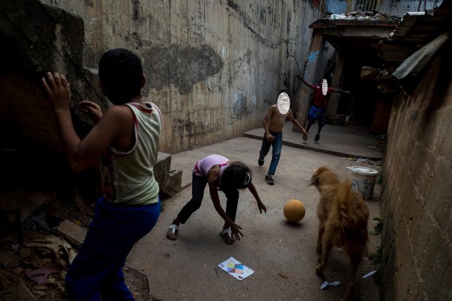 ACOMPAÑA CRÓNICA: VENEZUELA CRISIS. CAR03. CARACAS (VENEZUELA), 24/12/2017.- Niños juegan con una pelota este viernes, 22 de diciembre de 2017, en una barriada de Petare, en Caracas (Venezuela). El Niño Jesús no llevará regalos a muchos de los hogares de escasos recursos de Venezuela, pese a los millones de juguetes que el Gobierno de Nicolás Maduro ha asegurado que repartirá en todo el país, pues las familias dicen sentirse abandonadas y sumergidas en la crisis económica y social. EFE/Miguel Gutiérrez