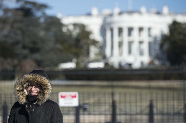 A tourist has a photo taken near the White House in Washington, DC on January 5, 2018. The National Weather Service said that very cold temperatures and wind chills will follow for much of the eastern third of the US through the weekend. A cold wave gripping a large section of the United States had already been blamed for a dozen deaths. / AFP PHOTO / ANDREW CABALLERO-REYNOLDS