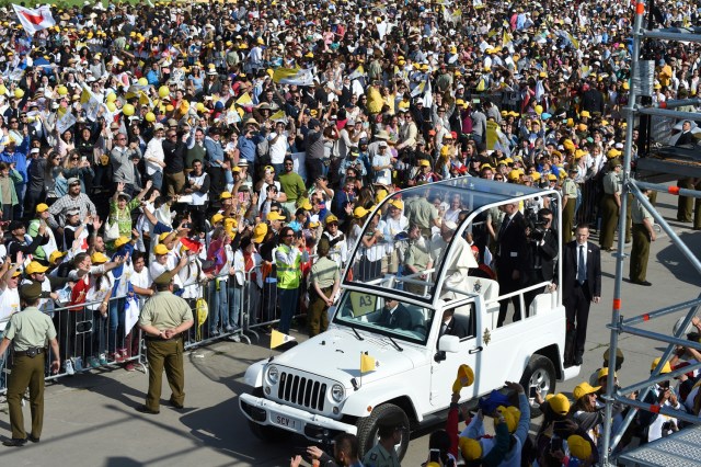 Pope Francis waves at the crowd from the popemobile as he arrives at O'Higgins Park in Santiago on January 16, 2018 to give an open-air mass. The pope landed in Santiago late Monday on his first visit to Chile since becoming pope, and his sixth to Latin America - a trip that will also take him to Peru. / AFP PHOTO / Pablo PORCIUNCULA BRUNE