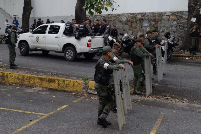 Security forces block access to the morgue in Caracas where the bodies of rogue pilot Oscar Perez and six other "terrorists" killed during a bloody police assault to arrest them, are being kept on January 17, 2018. Venezuela's government announced Tuesday that Perez was among seven "terrorists" killed when police swooped on them outside Caracas on Monday, setting off a fierce gunbattle in which two police officers were also killed. Perez had been wanted since he used a stolen helicopter to bomb Venezuela's Supreme Court at the height of anti-government protests last June. / AFP PHOTO / Federico PARRA