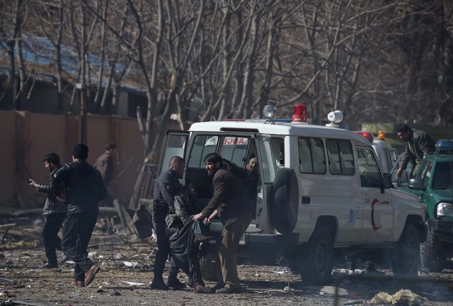 Afghan volunteers and policemen carry injured men on an ambulance at the scene of a car bomb exploded in front of the old Ministry of Interior building in Kabul on January 27, 2018. An ambulance packed with explosives blew up in a crowded area of Kabul on January 27, killing at least 17 people and wounding 110 others, officials said, in an attack claimed by the Taliban.  / AFP PHOTO / WAKIL KOHSAR