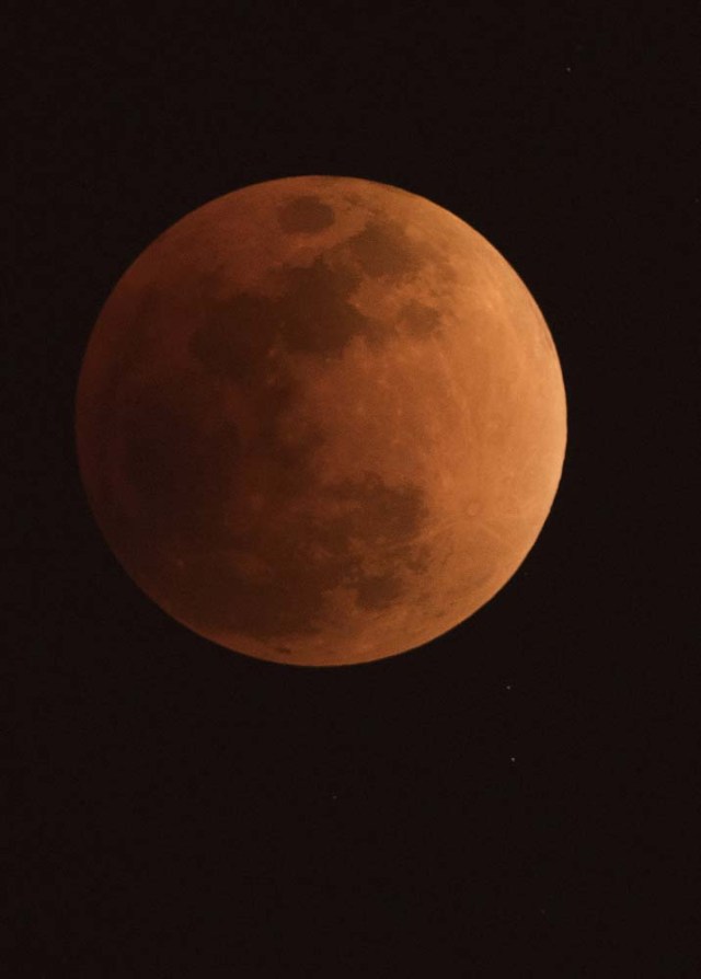 The moon is seen during a lunar eclipse, referred to as the "super blue blood moon", in Beijing on January 31, 2018. Skywatchers were hoping for a rare lunar eclipse that combines three unusual events -- a blue moon, a super moon and a total eclipse -- which was to make for a large crimson moon viewable in many corners of the globe. / AFP PHOTO / NICOLAS ASFOURI