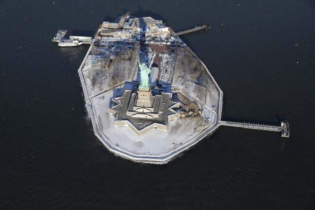 NEW YORK, NY - JANUARY 05: The Statue of Liberty stands on a snowy Liberty Island on January 5, 2018 in New York City. New York City dug out from the "Bomb Cyclone" under frigid temperatures. John Moore/Getty Images/AFP