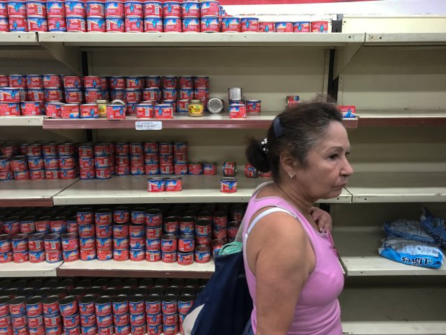 A woman looks for groceries and goods at a supermarket in Caracas, Venezuela January 6, 2018. REUTERS/Marco Bello