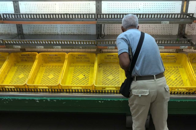 A man looks at an empty refrigerator in a supermarket in Caracas, Venezuela January 9, 2018. REUTERS/Marco Bello