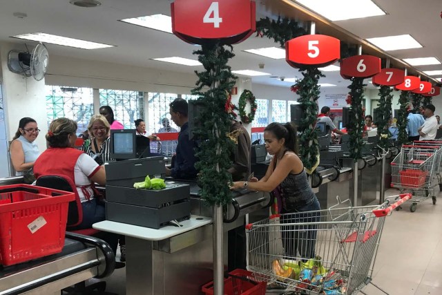 People line up at checkout counters in a supermarket in Caracas, Venezuela January 9, 2018. REUTERS/Marco Bello