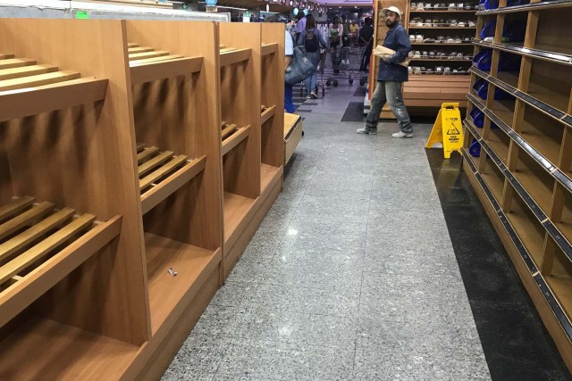 A man walks past empty shelves at the bakery area in a supermarket in Caracas, Venezuela January 10, 2018. REUTERS/Marco Bello