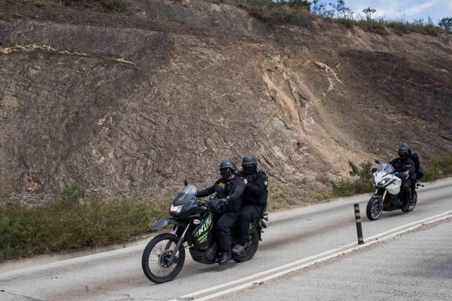 CAR11. CARACAS (VENEZUELA), 15/01/2018.- Agentes de las Fuerzas Armadas Bolivarianas cruzan en una motocicleta hacia el lugar donde se realiza una operación contra el grupo liderado por el policía Óscar Pérez hoy, lunes 15 de enero de 2018, en el barrio El Junquito, en Caracas (Venezuela). Las autoridades venezolanas desarticularon hoy el grupo liderado por el policía Oscar Pérez, acusado de "ataque terrorista" al Supremo, e informaron de haber "abatido" a un grupo no identificado de sus miembros y detenido a cinco. EFE/Miguel Gutiérrez