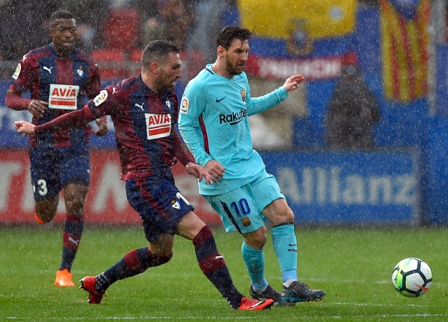 Barcelona's Argentinian forward Lionel Messi (R) vies with Eibar's Spanish defender Anaitz Arbilla during the Spanish league football match between SD Eibar and FC Barcelona at the Ipurua stadium in Eibar on February 17, 2018. / AFP PHOTO / ANDER GILLENEA