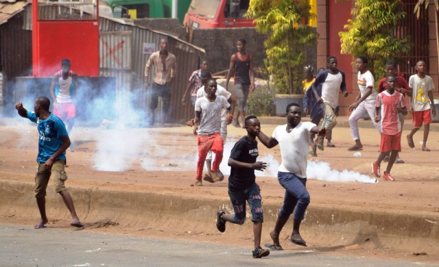 People clash with riot police during a demonstration against the results of the local elections, on February 6, 2018 in Conakry. Guinean opposition leaders on denounced the west African country's long-delayed local elections as fraudulent, citing vote rigging in polling stations across the west African country. / AFP PHOTO / CELLOU BINANI