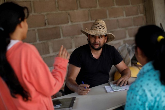 Yone Escalante (C) talks with farmers at the garage used to load his trucks in La Grita, Venezuela January 29, 2018. REUTERS/Carlos Garcia Rawlins SEARCH "LAWLESS ROADS" FOR THIS STORY. SEARCH "WIDER IMAGE" FOR ALL STORIES.?