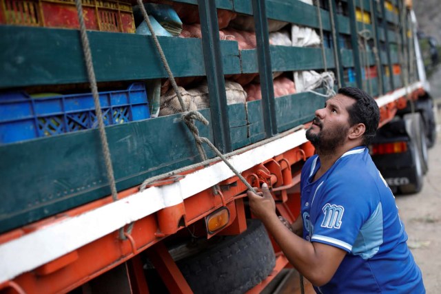 Humberto Aguilar ties a rope on a truck loaded with vegetables that will be sold in Caracas at his street market, in La Grita, Venezuela January 29, 2018. REUTERS/Carlos Garcia Rawlins SEARCH "LAWLESS ROADS" FOR THIS STORY. SEARCH "WIDER IMAGE" FOR ALL STORIES.?