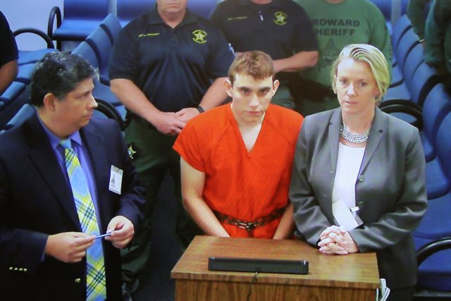 Nikolas Cruz (C) aparece a través de un monitor de video con Melisa McNeill (R), su defensora pública, en una audiencia ante un tribunal de fianzas después de ser acusada de 17 cargos de asesinato premeditado, en Fort Lauderdale, Florida, EE. UU., 15 de febrero de 2018. REUTERS / Susan Stocker / Pool