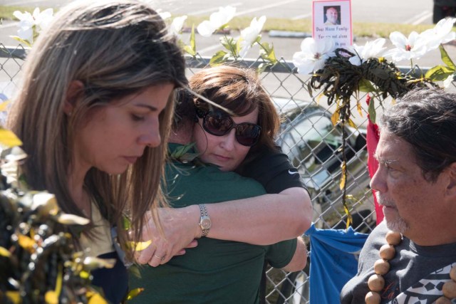 Parkland Mayor Christine Hunschofsky receives a hug as she and other government officials mourn, as students and parents arrive for voluntary campus orientation at the Marjory Stoneman Douglas High School, for the coming Wednesday's reopening, following last week's mass shooting in Parkland, Florida, U.S., February 25, 2018. REUTERS/Angel Valentin NO RESALES. NO ARCHIVES