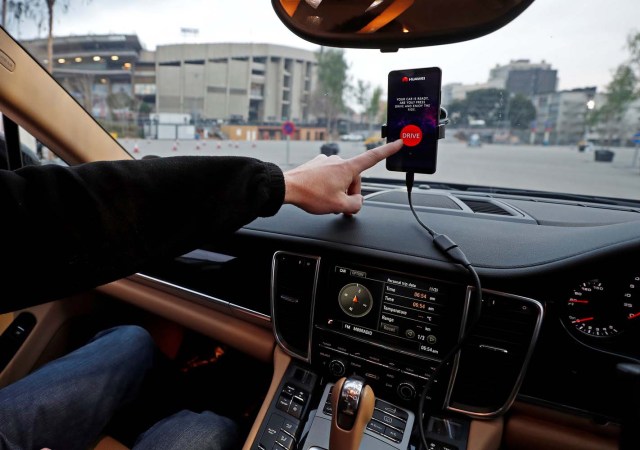 An engineer points to a Huawei Mate 10 Pro mobile used to control a driverless car during the Mobile World Congress in Barcelona, Spain February 26, 2018. REUTERS/Yves Herman