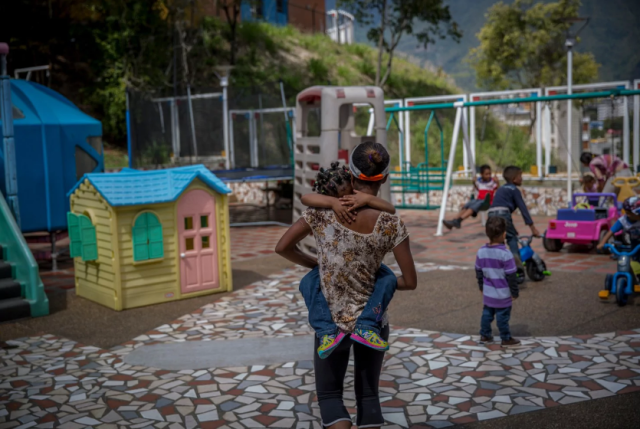  Dayana Silgado lleva a su hija al patio de recreo minutos antes del final de una visita a Fundana. Silgado no puede proporcionar suficiente comida para sus hijos, por lo que colocó a dos de ellos en el centro. (Alejandro Cegarra for The Washington Post