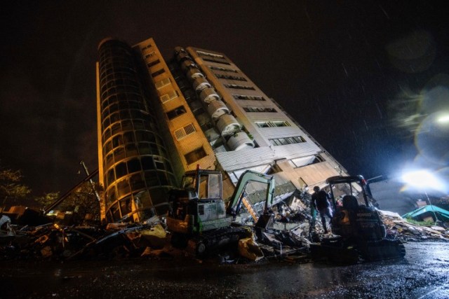 Un trabajador de rescate camina frente al edificio Yun Tsui después de un terremoto en la ciudad taiwanesa de Hualien el 7 de febrero de 2018. / AFP PHOTO / Anthony WALLACE