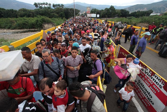 Venezuelan citizens cross the Simon Bolivar international bridge from San Antonio del Tachira in Venezuela to Norte de Santander province of Colombia on February 10, 2018. Oil-rich and once one of the wealthiest countries in Latin America, Venezuela now faces economic collapse and widespread popular protest.  / AFP PHOTO / GEORGE CASTELLANOS