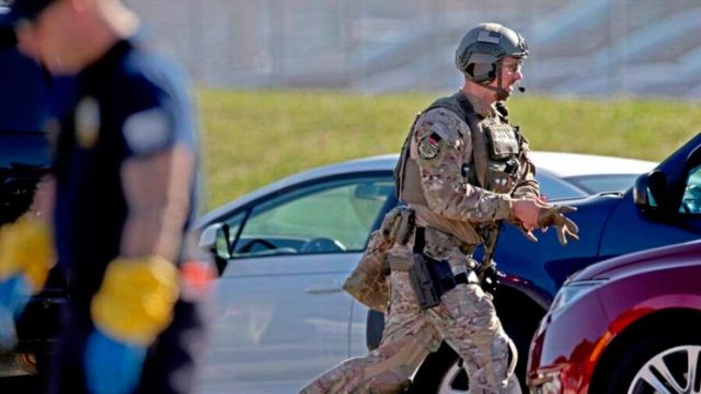 Un agente corre hacia la escuela secundaria Marjory Stoneman Douglas en Parkland, Florida, el 14 de febrero de 2018, luego de reportes sobre un tiroteo en ese centro escolar. John McCall Sun Sentinel