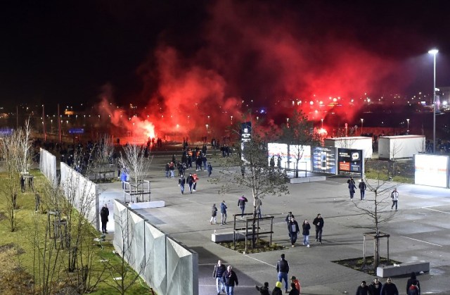 En esta foto de archivo tomada el 15 de marzo de 2018, los fanáticos de Lyon usan bengalas rojas antes del partido de fútbol Europa League Olympique Lyonnais (OL) vs CSKA Moscú el 15 de marzo de 2018, en el estadio Groupama en Decines-Charpieu, central- este de Francia. La UEFA, el 19 de marzo de 2018, acusó al club francés Lyon de comportamiento racista y desorden público en el partido de la Europa League de la semana pasada contra el CSKA de Moscú.  ROMAIN LAFABREGUE / AFP