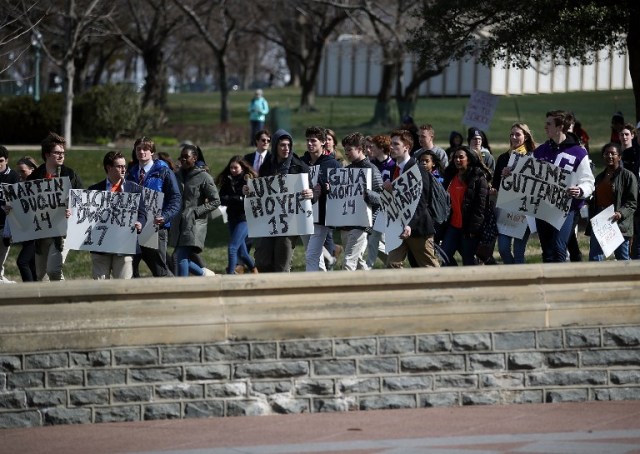 WASHINGTON, DC - MARCH 14: Students from the Washington area carry signs as they march to the U.S. Capitol to urge Congress to take action against gun violence on March 14, 2018 on Capitol Hill in Washington, DC. It was one month ago today that a gunman killed 17 people at Marjory Stoneman Douglas High School in Parkland, Florida. Mark Wilson/Getty Images/AFP