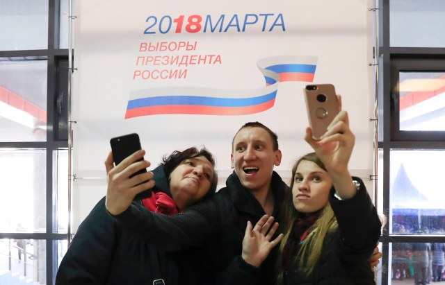 La gente toma fotos de autofoto mientras visitan una mesa de votación durante las elecciones presidenciales en Moscú, Rusia, el 18 de marzo de 2018. REUTERS / Tatyana Makeyeva