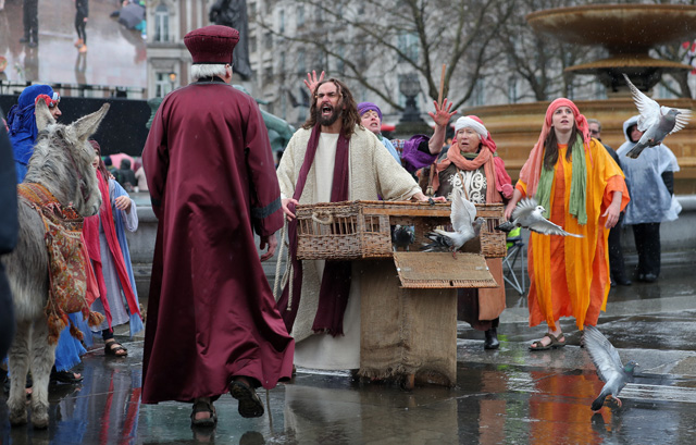 Actor James Burke-Dunsmore (C) plays the role of Jesus Christ, during a performance of Wintershall's 'The Passion of Jesus' on Good Friday in Trafalgar Square in London on March 30, 2018.  The Passion of Jesus tells the story from the Bible of Jesus's visit to Jerusalem and his crucifixion. On Good Friday 20,000 people gather to watch the Easter story in central London. One hundred Wintershall players bring their portrayal of the final days of Jesus to this iconic location in the capital. / AFP PHOTO / Daniel LEAL-OLIVAS