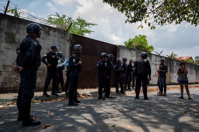 VALENCIA (VENEZUELA), 28/03/2018.- Un grupo de familiares de presos hablan con miembros de la Policía hoy, miércoles 28 de marzo de 2018, en las inmediaciones del centro de reclusión de la Policía Estatal de Carabobo (centro) en Valencia (Venezuela). Un motín en el centro de reclusión de la Policía de Carabobo (centro) de Venezuela dejó hoy cinco reclusos muertos y dos policías heridos, según medios locales. EFE/Miguel Gutiérrez