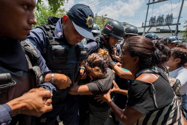 VALENCIA (VENEZUELA), 28/03/2018.- Un grupo de familiares de presos protesta ante miembros de la Policía hoy, miércoles 28 de marzo de 2018, en las inmediaciones del centro de reclusión de la Policía Estatal de Carabobo (centro) en Valencia (Venezuela). Un motín en el centro de reclusión de la Policía de Carabobo (centro) de Venezuela dejó hoy cinco reclusos muertos y dos policías heridos, según medios locales. EFE/Miguel Gutiérrez